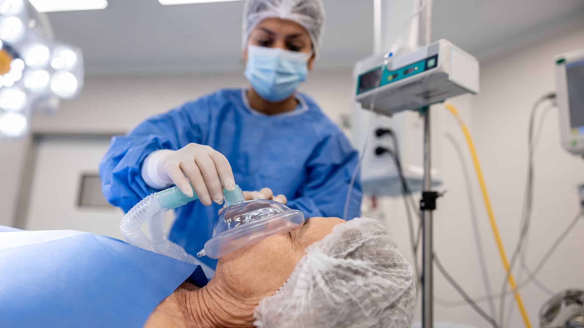Anästhesist setzt Patienten unter Narkose eine Sauerstoffmaske auf