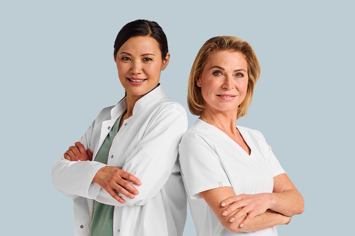 Zwei lächelnde Ärztinnen stehen Schulter an Schulter